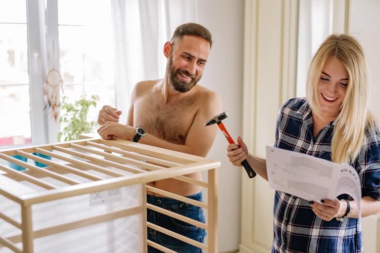 Husband and wife building baby furniture for a nursery