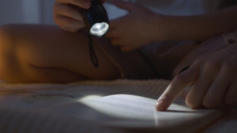 Reading a book with a flashlight