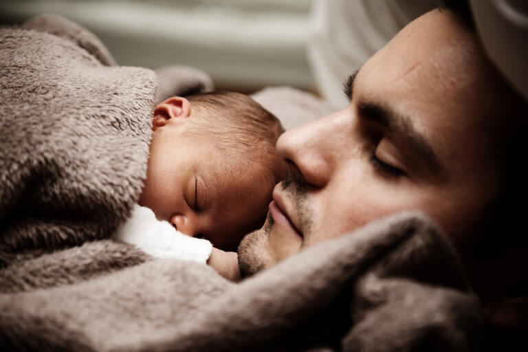 Father sleeping with his baby
