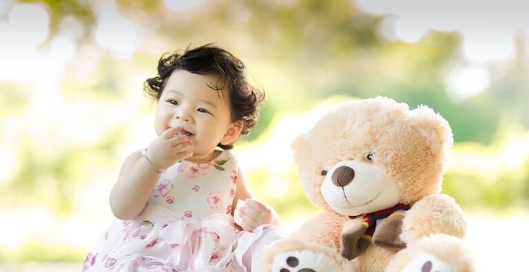 Girl outside with her hands in her mouth