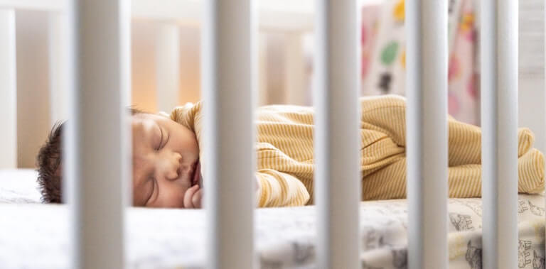 Newborn baby sleeping alone in a side sleeper