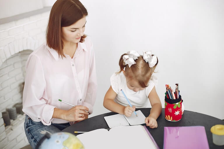 Little girl doing arts and crafts with her mother