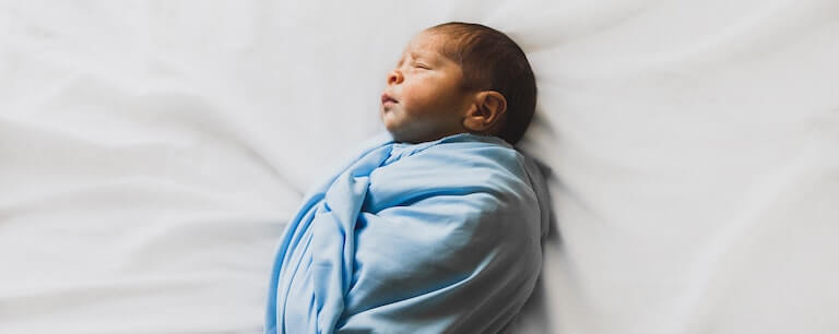 A swaddled newborn baby