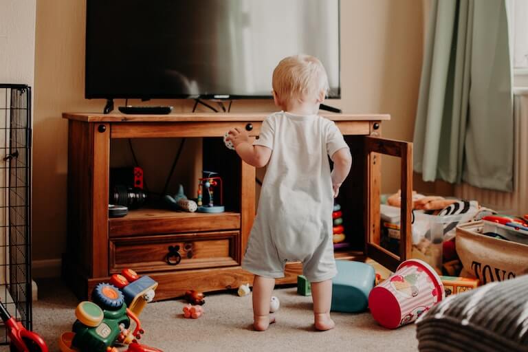 Baby playing in living room with toys all around him