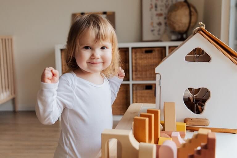 https://www.citybabytips.com/static/baby-tips/how-to-baby-proof-your-apartment/little-girl-smiling-and-playing.jpg
