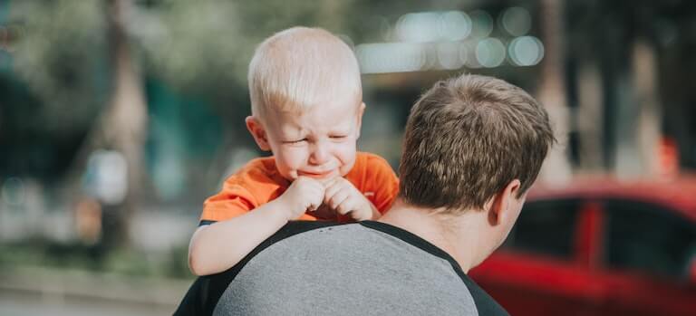 Father holding his crying son