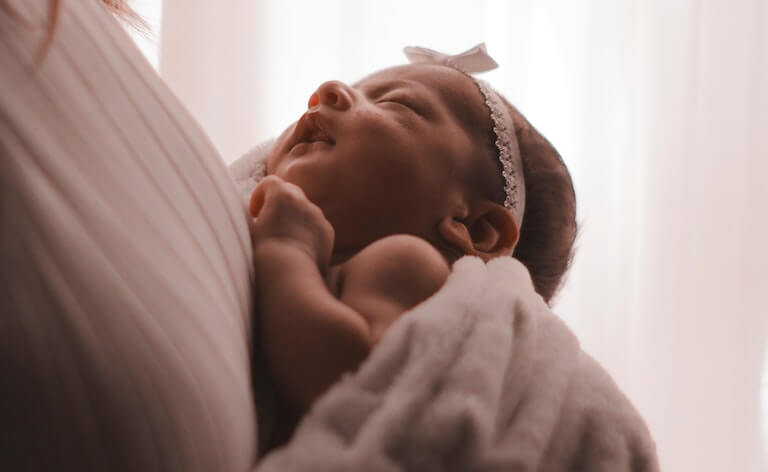 Baby asleep in their mothers arms