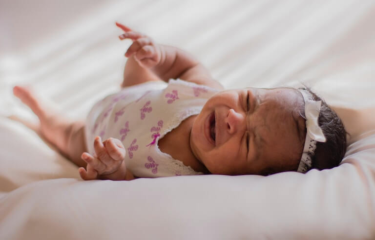 Baby girl on her back crying