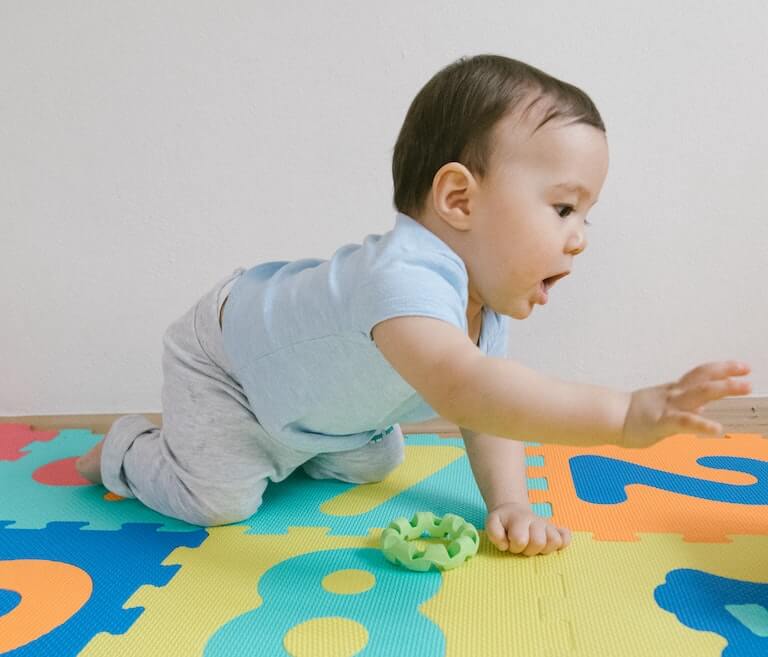 Boy crawling on a mat