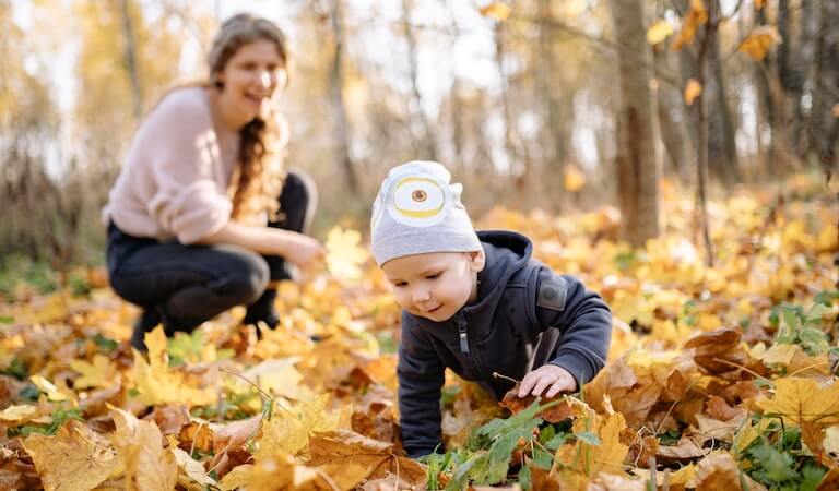Boy crawling outside on leaves