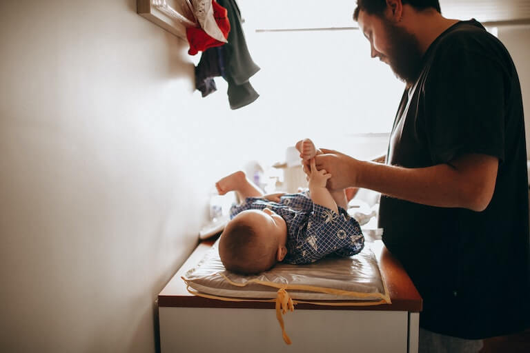 Dad changing his baby's diaper