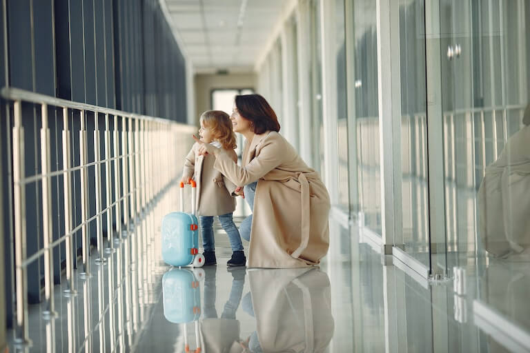 Mom and daughter in the airport with a tiny suitcase