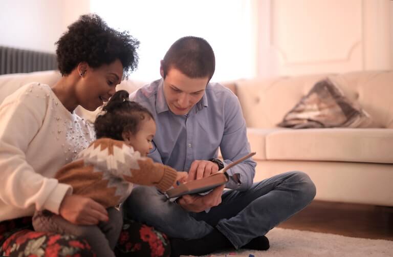 Parents teaching their daughter how to read