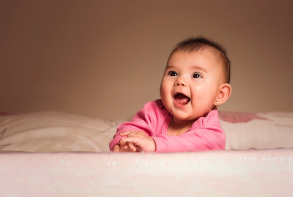 Happy baby girl smiling in a pink shirt