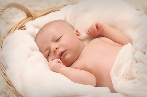 Newborn baby sleeping comfortably in bed