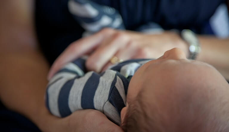 Baby sleeping in their parents arms