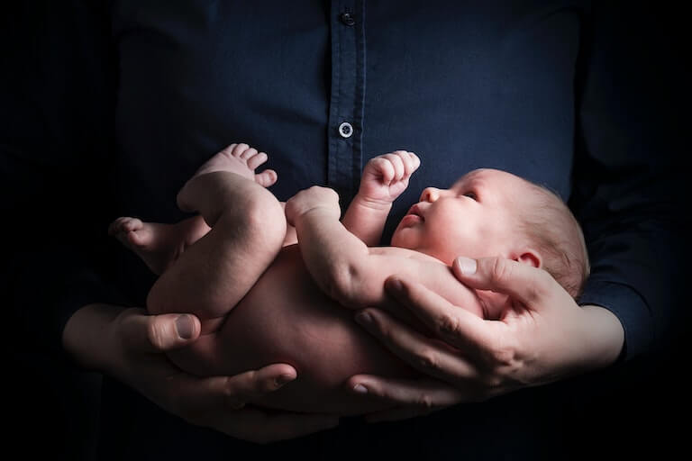 Small baby in their fathers arms