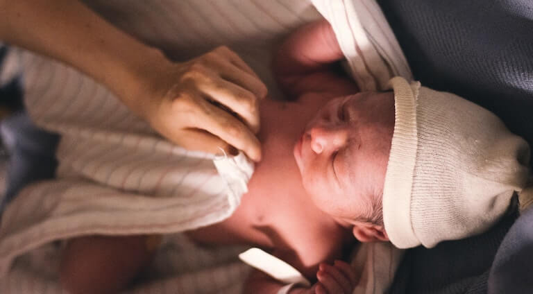 Newborn baby being clothed
