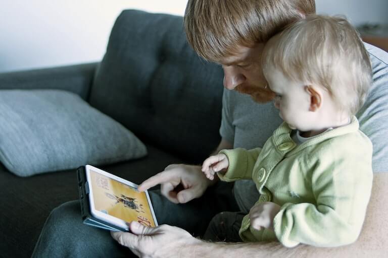 Baby and father looking at a tablet computer