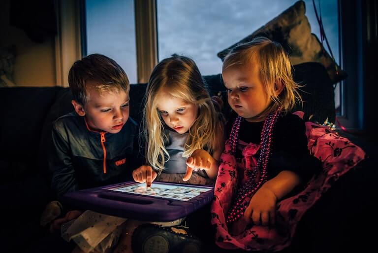 Children gathered around a tablet computer