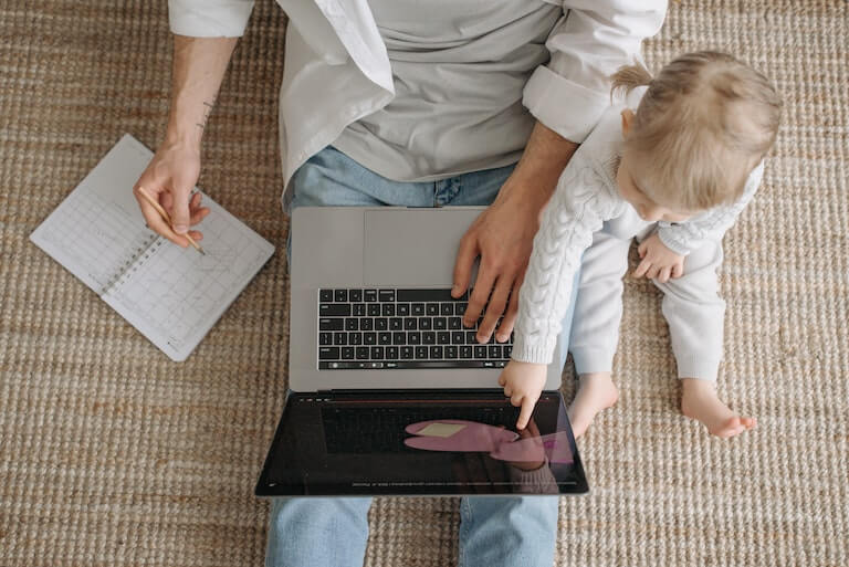 Parent on a laptop computer with her child