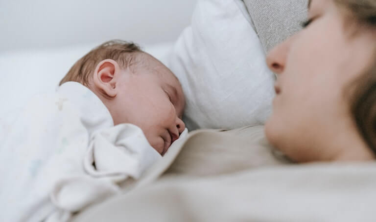 Mom sleeping with newborn baby