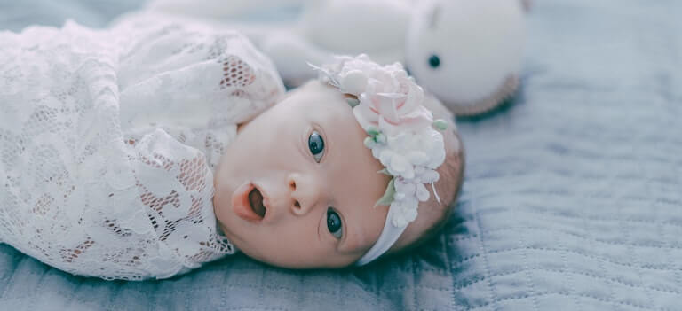 Newborn baby in a white swaddle