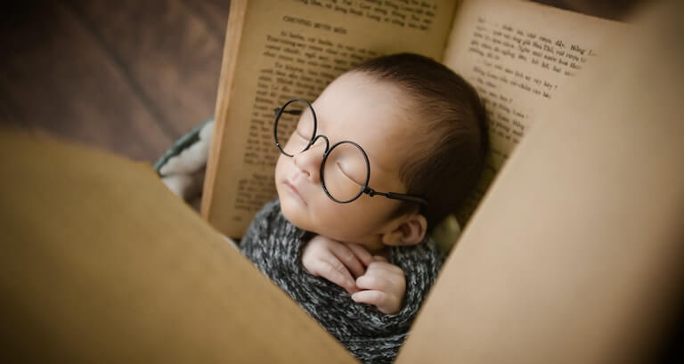 Swaddled baby with glasses on