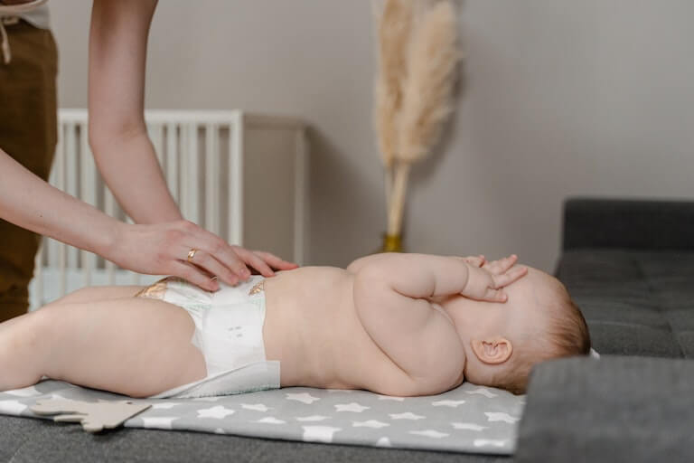 Baby in a diaper covering their face