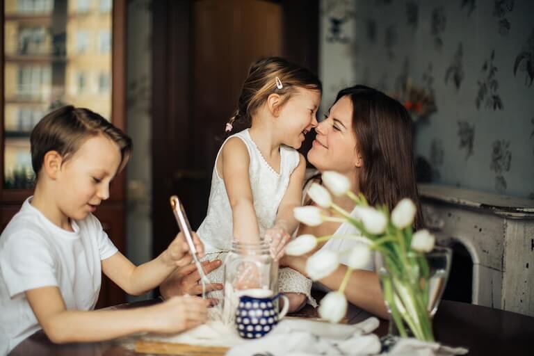 Happy mom at the dining room table with son and daughter