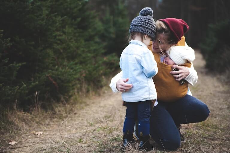Mom outside with a baby and a small child