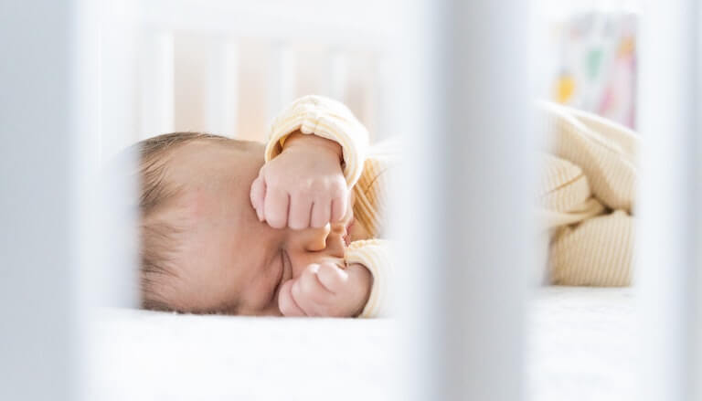 Baby asleep covering their eyes