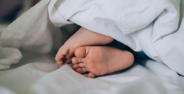 Baby feet under a blanket