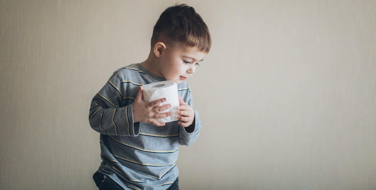 Boy walking around with a roll of toilet paper